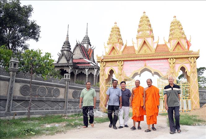 Ông Danh Út (bìa trái) thường xuyên đến chùa Khmer để cùng với sư sãi tuyên truyền chủ trương của Đảng, chính sách pháp luật của Nhà nước cho các phật tử. Ảnh: Lê Sen - TTXVN
