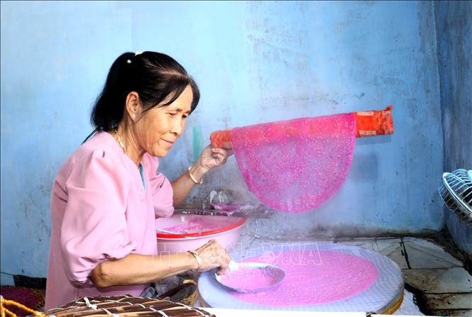 Bà Trần Thị Thúy Liễu (xã Lục Sỹ Thành, huyện Trà Ôn, tỉnh Vĩnh Long) khéo léo tráng từng chiếc bánh tráng thanh long. Ảnh: Lê Thúy Hằng - TTXVN