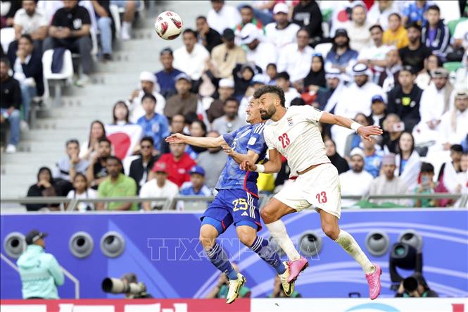 Pha tranh bóng bổng giữa tiền đạo Nhật Bản Daizen Maeda (trái) và hậu vệ Iran Ramin Rezaeian. Ảnh: AFP/TTXVN