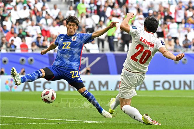 Pha tranh bóng bổng giữa hậu vệ Nhật Bản Takehiro Tomiyasu (trái) và tiền đạo Iran Sardar Azmoun. Ảnh: AFP/TTXVN