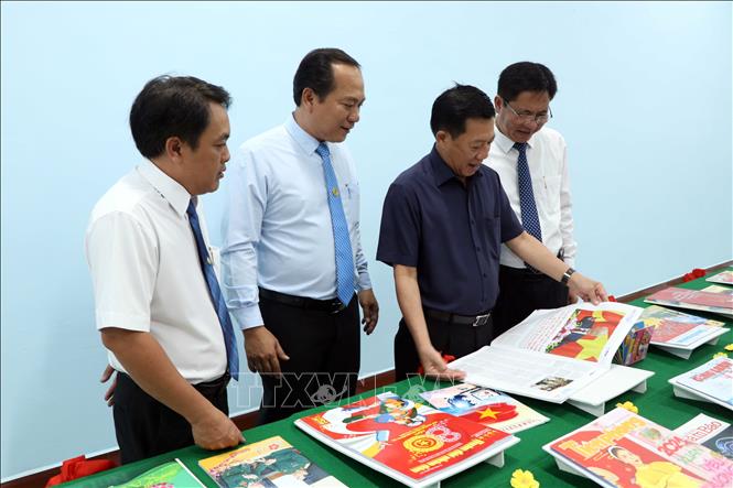 Ông Dương Huỳnh Khải, Phó Chủ tịch HĐND tỉnh Cà Mau xem ấn phẩm của TTXVN trưng bày tại Hội báo Xuân 2024. Ảnh: Kim Há-TTXVN 