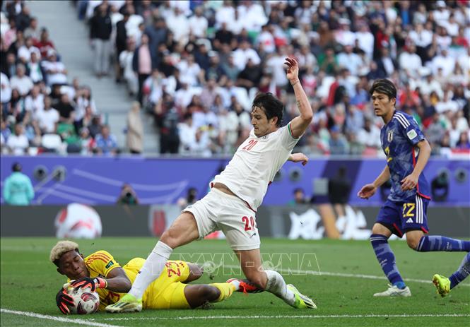 Tiền đạo Iran Sardar Azmoun (thứ 2, trái) tranh bóng với thủ thành Suzuki Zion (trái) của Nhật Bản. Ảnh: THX/TTXVN
