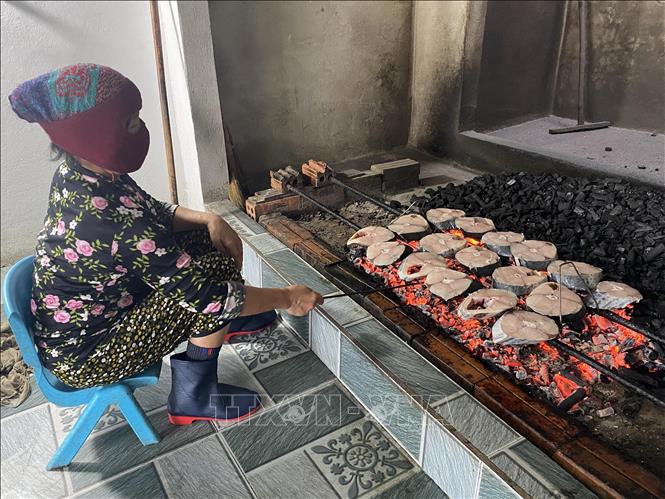 Bà Nguyễn Thị Vân, thôn Long Hải, xã Thạch Kim, đã có gần 40 năm làm nghề nướng cá. Ảnh: Hữu Quyết – TTXVN