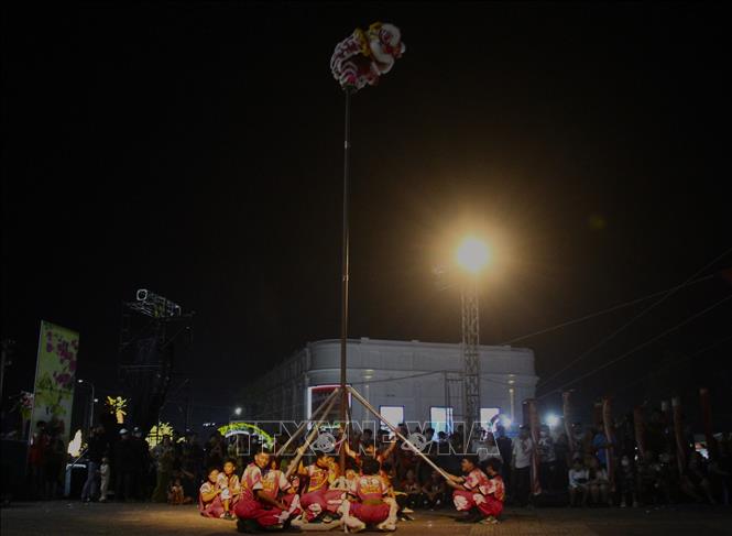  Phần thi Lân sư rồng leo cột hái lộc. Ảnh: Nguyễn Hằng - TTXVN