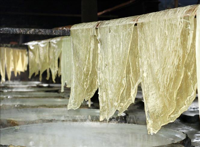 Các lá tàu hũ được hong khô bằng hơi nóng từ các chảo đậu nành. Ảnh: Lê Thúy Hằng – TTXVN