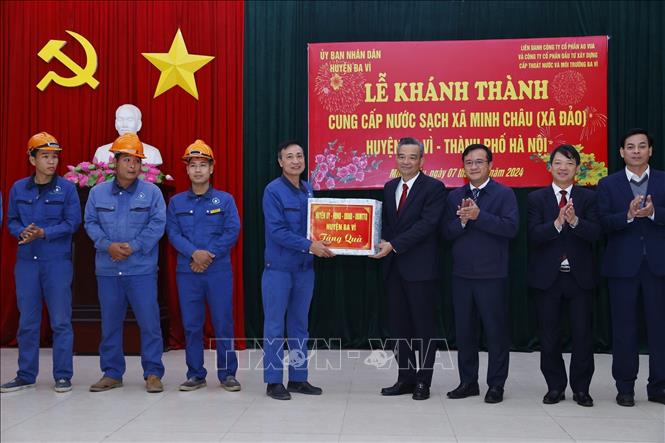 Lãnh đạo huyện Ba Vì tặng quà cho đơn vị thi công đường ống nước sạch tới xã Minh Châu. Ảnh: Minh Quyết – TTXVN
