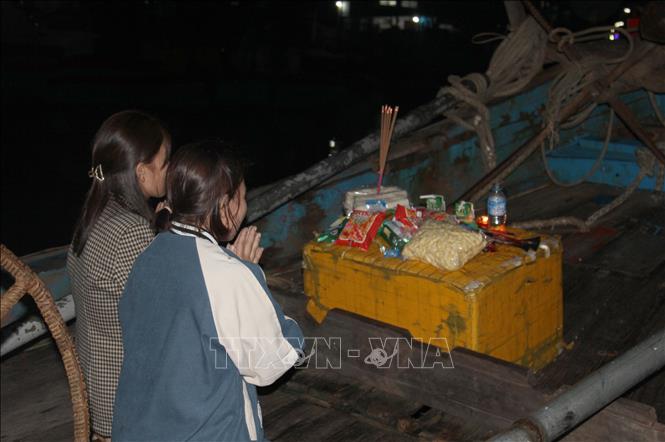 Các thành viên là người thân, họ hàng hoặc ngư dân cùng chung sở hữu chiếc thuyền thực hiện nghi thức cúng thuyền. Ảnh: Xuân Tiến - TTXVN 