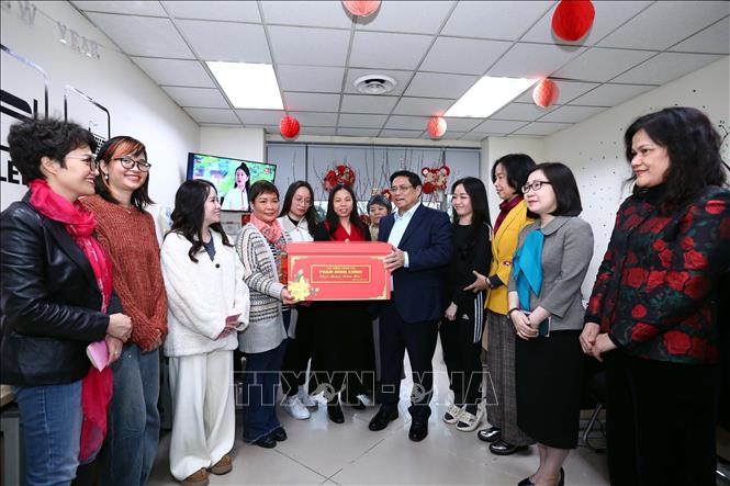 Thủ tướng Phạm Minh Chính tặng quà Tết cho phóng viên, biên tập viên Ban Biên tập Tin Thế giới. Ảnh: Huy Hùng - TTXVN