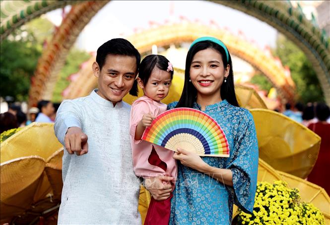 Một gia đình trẻ check-in ở Đường hoa Nguyễn Huệ Tết Giáp Thìn 2024.
Ảnh: Hồng Đạt - TTXVN
