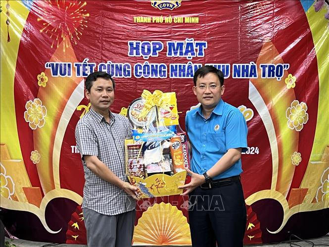 Ông Phùng Thái Quang, Phó Chủ tịch Liên đoàn Lao động Thành phố Hồ Chí Minh tặng quà cho chủ khu nhà trọ 63A Lê Trọng Tấn, quận Tân Phú, Thành phố Hồ Chí Minh. Ảnh: Thanh Vũ - TTXVN
