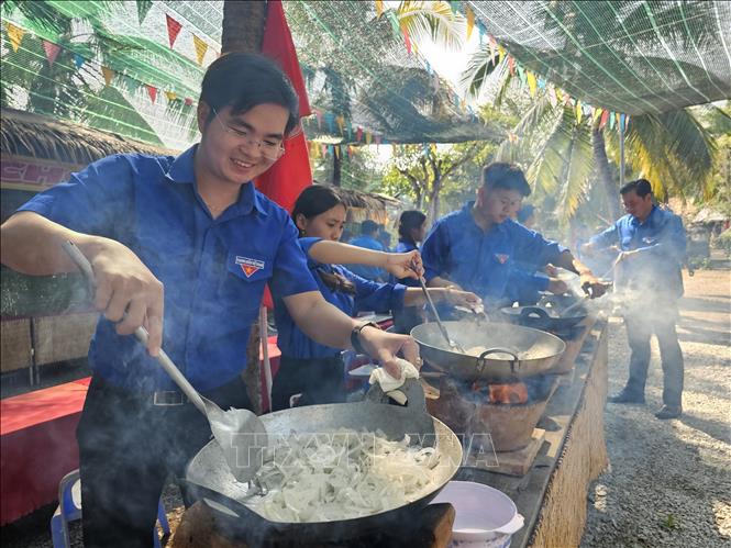 The most important skill to make candied coconut ribbons is to control the heat when coating sugar on the coconut. VNA Photo: Chương Đài
