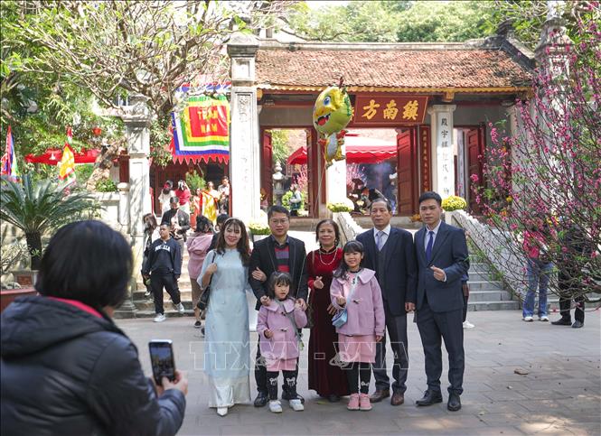Một gia đình lưu giữ kỷ niệm mùng 3 Tết Giáp Thìn tại đền Kim Liên, nơi thờ thần Cao Sơn Đại vương - trấn ở phía Nam Hà Nội. Ảnh: Hoàng Hiếu - TTXVN