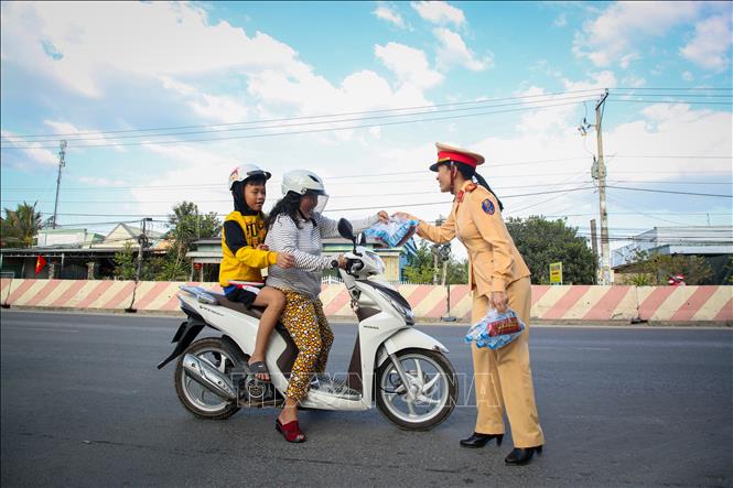 Người dân hạnh phúc khi nhận món quà từ các cán bộ chiến sĩ Cảnh sát giao thông Tây Ninh. Ảnh: Giang Phương - TTXVN