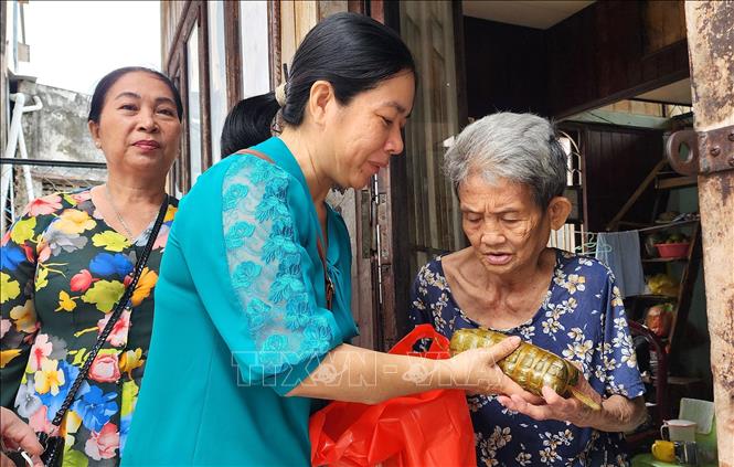 Lãnh đạo địa phương và các đoàn thể đến thăm và tặng bánh tét cho các hộ có hoàn cảnh khó khăn trên địa bàn phường 1, thành phố Vĩnh Long, tỉnh Vĩnh Long. Ảnh: Lê Thúy Hằng - TTXVN