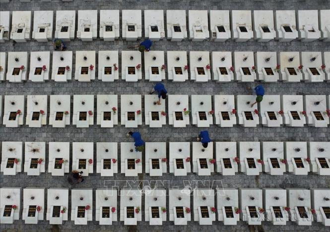 Thanh niên tình nguyện chăm sóc mộ phần các liệt sĩ đang yên nghỉ tại Nghĩa trang Liệt sĩ quốc gia Vị Xuyên (Hà Giang). Ảnh: Hoàng Hiếu - TTXVN