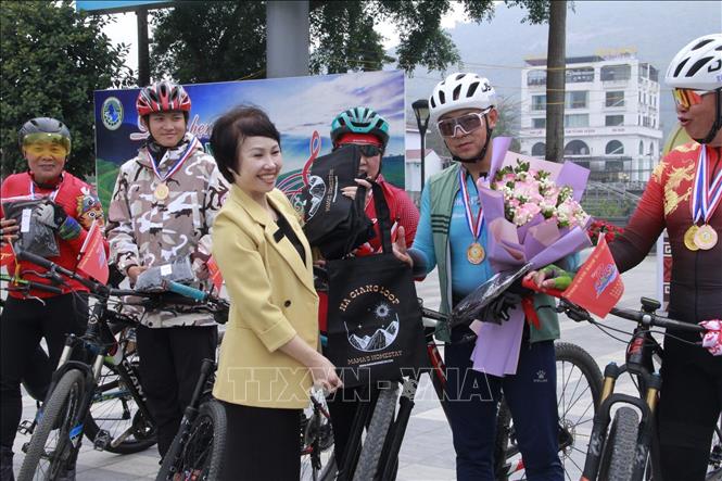 Ha Giang's local authorities present flowers and insignias to Chinese cyclists taking part in the tour. VNA Photo: Minh Tâm
