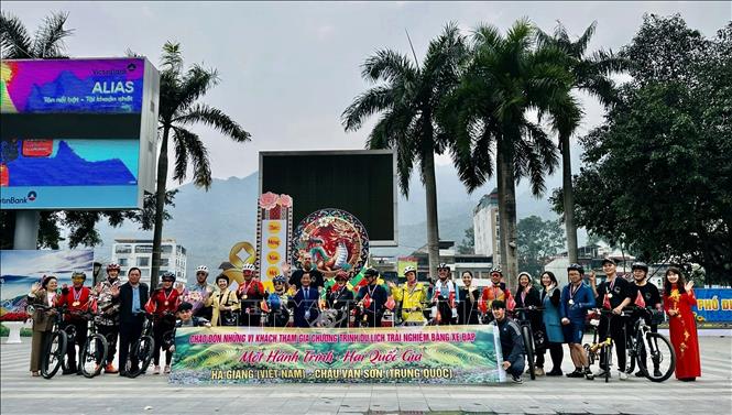 Ha Giang's local authorities and Chinese cyclists taking part in the tour pose for a group photo. VNA Photo: Minh Tâm