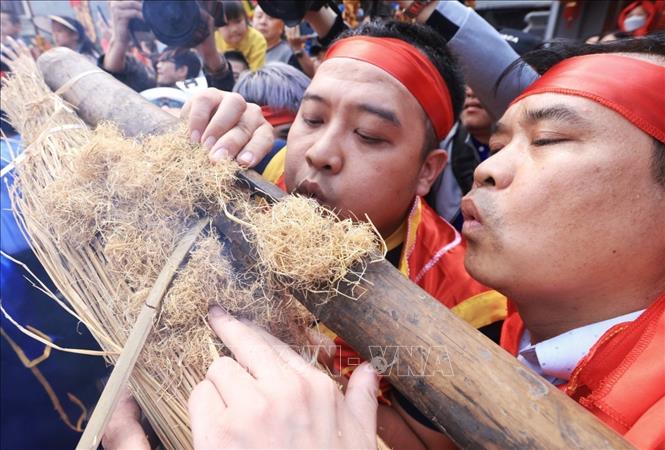 Thành viên các đội ra sức thổi vào bó rơm để lửa bén to. Ảnh: Tuấn Anh - TTXVN