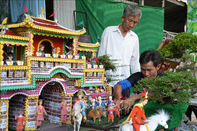 Người theo đạo Cao Đài điều chỉnh mô hình trưng bày trước giờ diễn ra Đại Lễ. Ảnh: Minh Phú - TTXVN