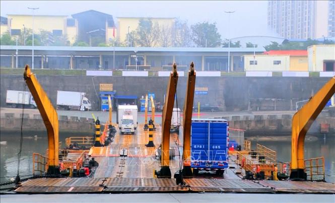 Xe chở hàng xuất khẩu qua lối mở cầu phao tạm km3+4 Hải Yên. Ảnh: Văn Đức - TTXVN