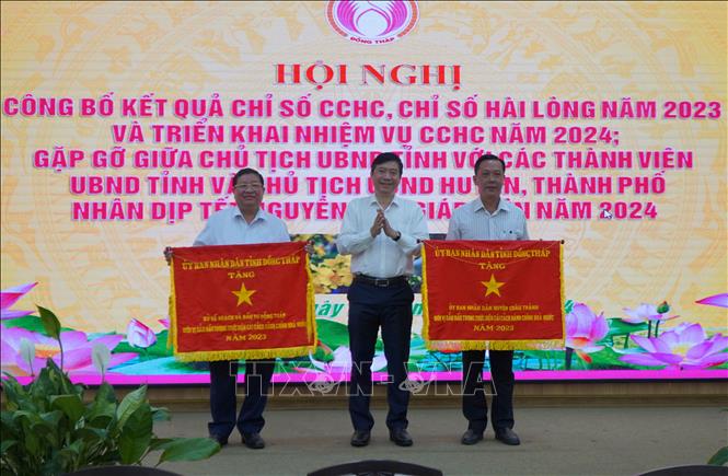 Trao Cờ thi đua của UBND tỉnh cho 2 tập thể. Ảnh: Nhựt An - TTXVN