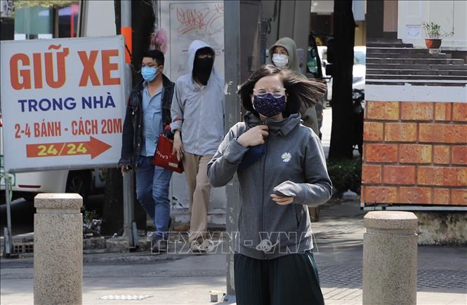 Người dân bận trang phục kín từ đầu đến chân để tránh cái nắng rát da trên đường phố Thành phố Hồ Chí Minh. Ảnh: Hồng Giang - TTXVN.