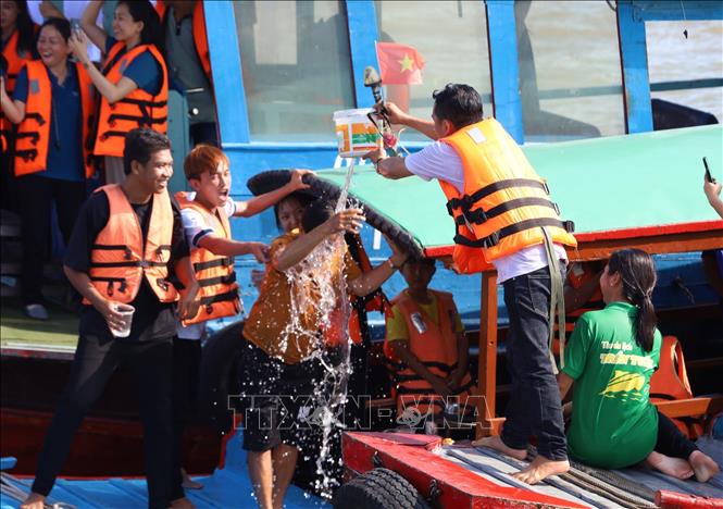 Dội nước cho nhau để cầu bình an và may mắn. Ảnh: Ánh Tuyết - TTXVN