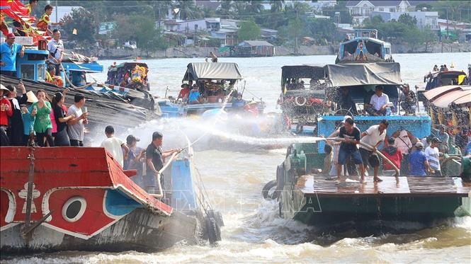 Phun nước giữa các tàu để cầu mong may mắn cho năm mới. Ảnh: Ánh Tuyết - TTXVN
