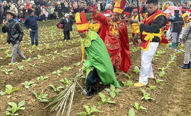 Đi đầu đoàn Lễ là 2 ông Chánh tướng và Phó tướng đội mũ rồng, trang phục xanh lá cây và đỏ, vừa đi vừa thực hiện động tác dọn đường. Ảnh: Anh Tuấn – TTXVN