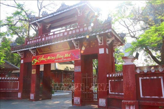 Cổng trường với lối kiến trúc cổ kính có hai tầng, tầng trên bằng gỗ, mái lợp ngói hoàng lưu ly.  Ảnh: Tường Vi - TTXVN
