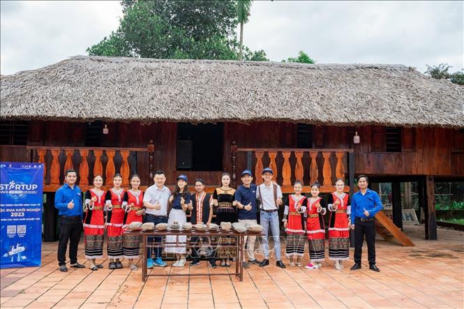 Nhóm các bạn trẻ Khanh Son Eco cùng đoàn khách du lịch chụp ảnh lưu niệm tại nhà dài của người đồng bào dân tộc Raglai, nhằm giới thiệu một sản phẩm văn hóa của huyện Khánh Sơn. Ảnh: TTXVN phát