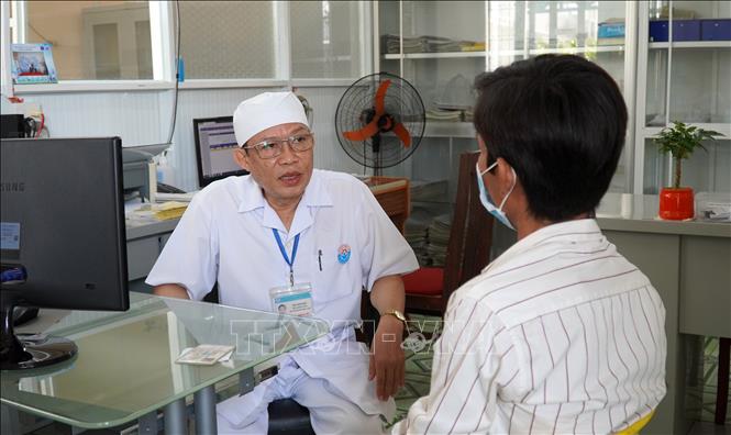 Bác sĩ CKI Bùi Văn Bời, Phó Trưởng Khoa Truyền nhiễm, Trung tâm Y tế huyện Giồng Riềng (Kiên Giang) khám bệnh cho người nhiễm HIV. Ảnh: Văn Sĩ-TTXVN                            