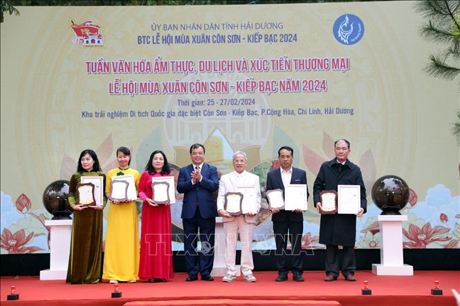 Trao giấy chứng nhận vinh danh thương hiệu ẩm thực xứ Đông cho các chủ thể sở hữu. Ảnh: Mạnh Tú - TTXVN
