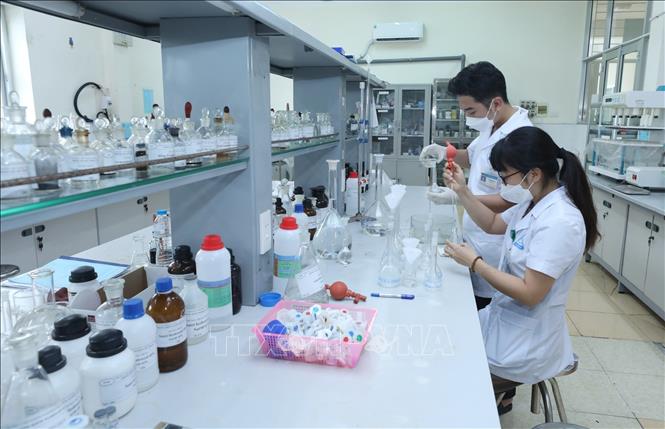 Cán bộ Trung tâm kiểm nghiệm thuốc, mỹ phẩm, thực phẩm tỉnh Lạng Sơn pha mẫu trong bình định mức trước khi phân tích mẫu. Ảnh: Anh Tuấn - TTXVN 