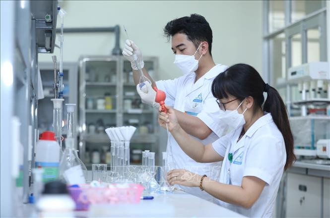 Cán bộ Trung tâm kiểm nghiệm thuốc, mỹ phẩm, thực phẩm tỉnh Lạng Sơn pha mẫu trong bình định mức trước khi phân tích mẫu. Ảnh: Anh Tuấn - TTXVN 