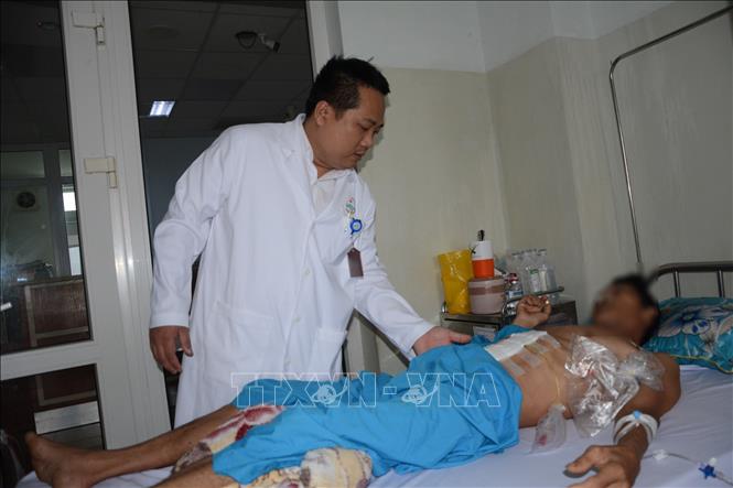 Bác sĩ Chuyên khoa II Nguyễn Văn Hải Vân khám cho bệnh nhân sau phẫu thuật. Ảnh: Văn Dũng-TTXVN