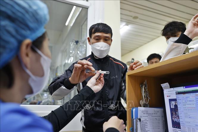 Người nhà bệnh nhân thông báo nhiệt độ của bệnh nhân (sốt 40 độ C) với điều dưỡng viên trực tại quầy. Ảnh: Minh Quyết – TTXVN