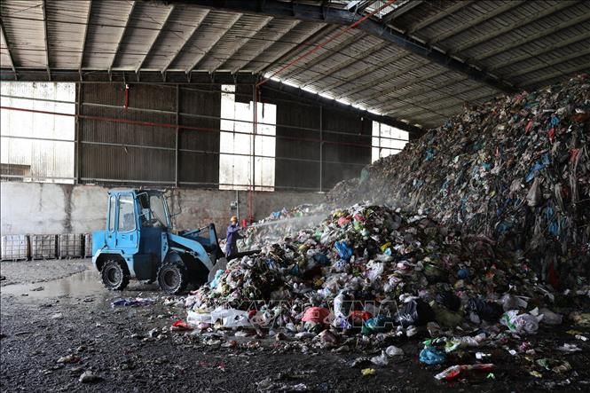Khu vực tập kết rác thải sinh hoạt từ các nguồn chuẩn bị xử lý tại Công ty trách nhiệm hữu hạn một thành viên môi trường xanh Huê Phương VN. Ảnh: Thanh Tân - TTXVN