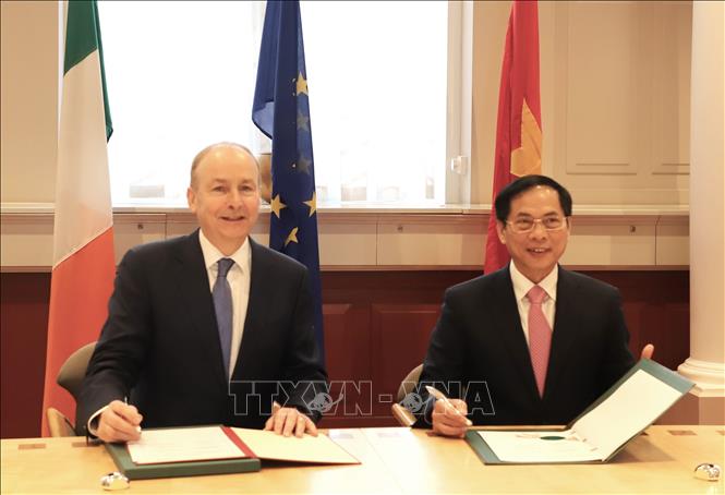 The foreign ministers sign an agreement to tighten cooperation between the two ministries. VNA Photo: Phong Hà