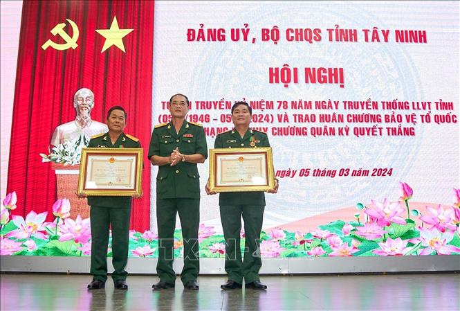 Đại tá Ngô Thành Đồng, Chỉ huy trưởng Bộ Chỉ huy Quân sự tỉnh Tây Ninh thừa uỷ quyền của Chủ tịch nước trao Huân chương Bảo vệ Tổ quốc hạng Ba cho 2 cá nhân. Ảnh: Giang Phương - TTXVN