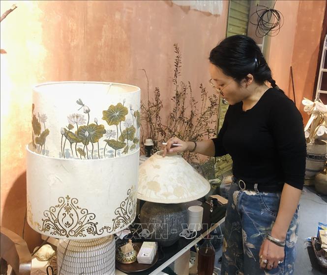 Đoàn Thái Cúc Hương tỉ mẩn chỉnh sửa từng chi tiết trên các sản phẩm của mình. Ảnh: Phương Lan - TTXVN
