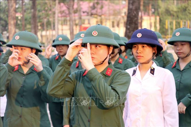 Động tác căn chỉnh mũ trước giờ chào cờ. Ảnh: Xuân Khu-TTXVN
