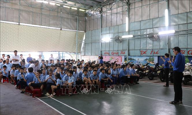 Trong giờ chào cờ, thầy giáo chia sẻ chủ điểm của tuần bằng lời cùng với một thầy giáo diễn đạt bằng ngôn ngữ ký hiệu, đảm bảo toàn bộ học sinh khuyết tật khiếm thính và trí tuệ đều nghe, nhìn thấy hiểu nội dung. Ảnh: Phan Sáu - TTXVN