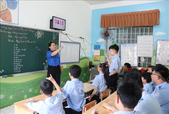 Một giờ học của học sinh khuyết tật khiếm thính khối 2-3, cô giáo hướng dẫn học sinh diễn đạt từ ngữ bằng ngôn ngữ ký hiệu. Ảnh: Phan Sáu - TTXVN