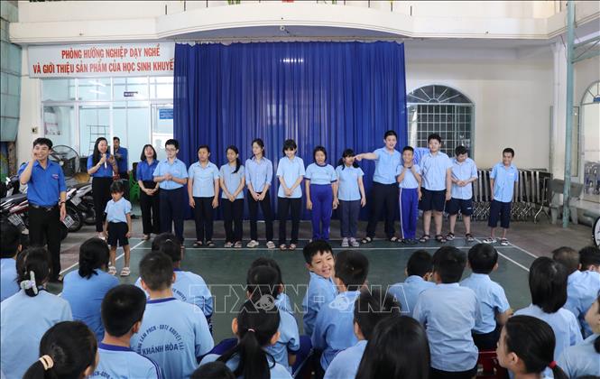 Khen ngợi, động viên học sinh khuyết tật bằng cách tuyên dương các em trước toàn thể giáo viên, học sinh của Trung tâm vào giờ chào cờ đầu tuần. Ảnh: Phan Sáu - TTXVN