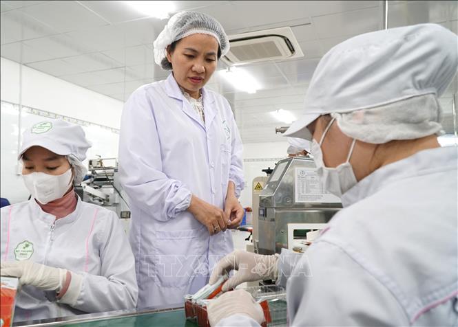 Chị Mai Thị Ý Nhi kiểm tra các công đoạn sản xuất bánh dừa nướng. Ảnh: Quốc Dũng - TTXVN