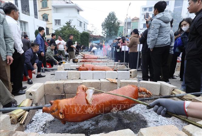 Các đội thực hiện phần thi quay lợn. Ảnh: Anh Tuấn – TTXVN