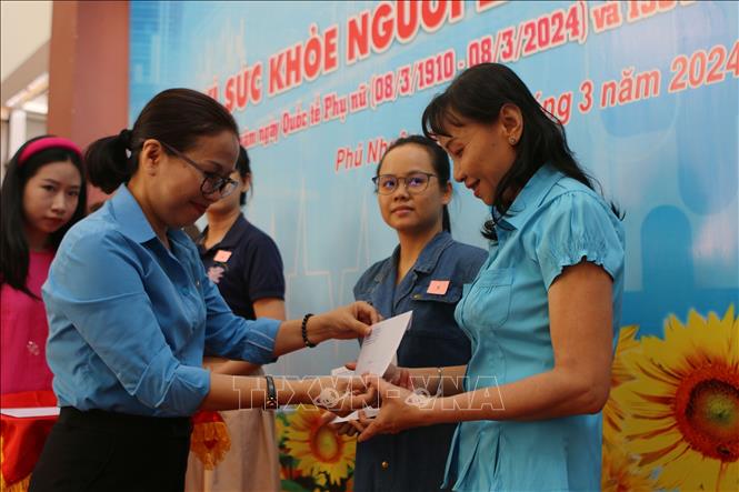  Lãnh đạo Liên đoàn Lao động Thành phố Hồ Chí Minh tặng quà cho công nhân lao động có hoàn cảnh khó khăn nhân dịp 8/3. Ảnh: Thanh Vũ - TTXVN
