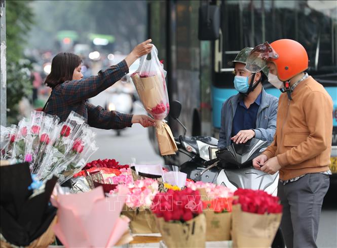 Các đấng mày râu mua hoa hồng tại một điểm bán trên phố Bà Triệu, chiều 7/3. Ảnh: Hoàng Hiếu - TTXVN