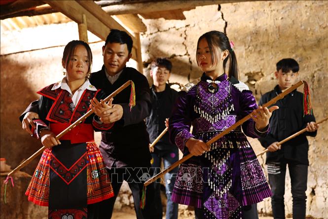 Anh Giàng Seo Lìn dạy múa gậy đồng xu cho các thế hệ sau tại thôn Thèn Ván, xã Pà Vầy Sủ, huyện Xín Mần. Ảnh: Minh Đức – TTXVN